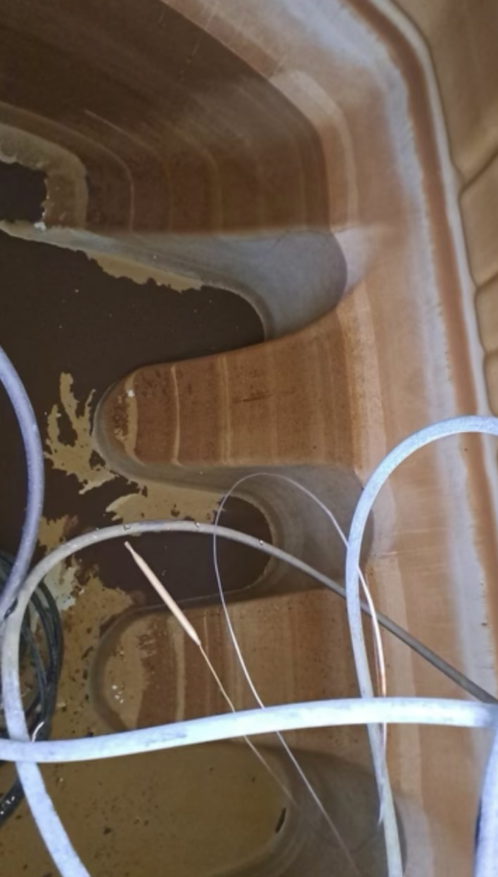 Dirty water tank before cleaning showing brown contamination and sediment buildup